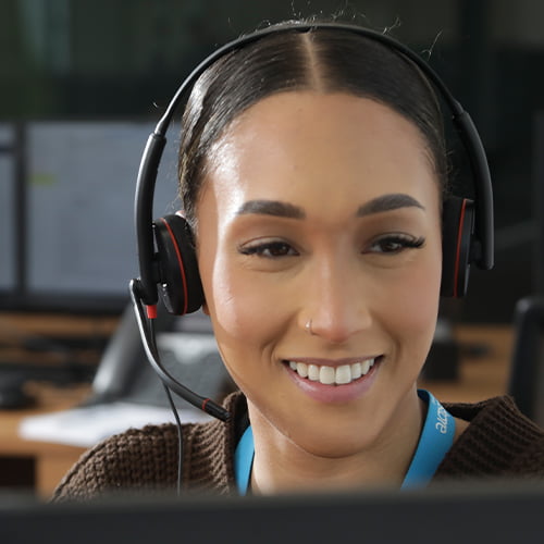 woman smiling with headset at computer
