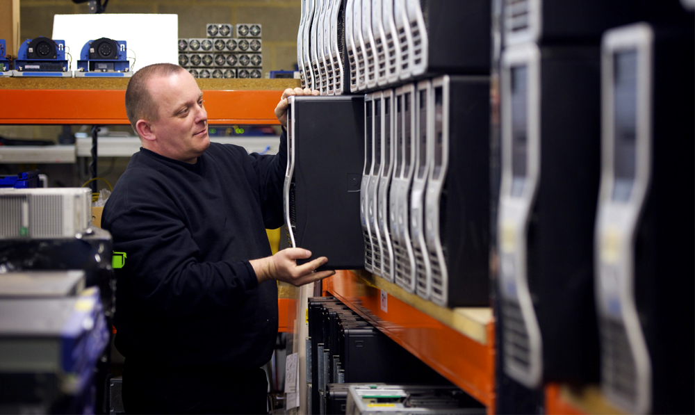 Man shelving computer on shelf as part of IT relocation