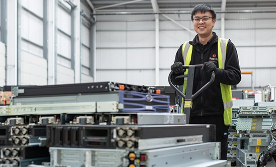 A happy warehouse worker moving tech of a forklift