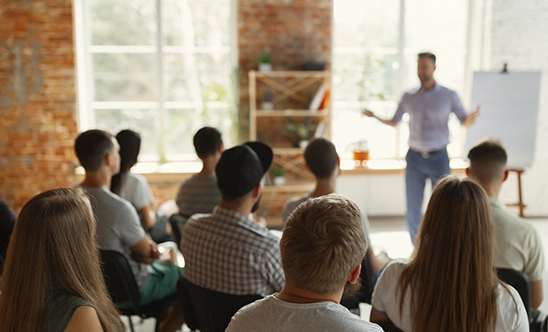 someone giving a lecture to train a room full of staff