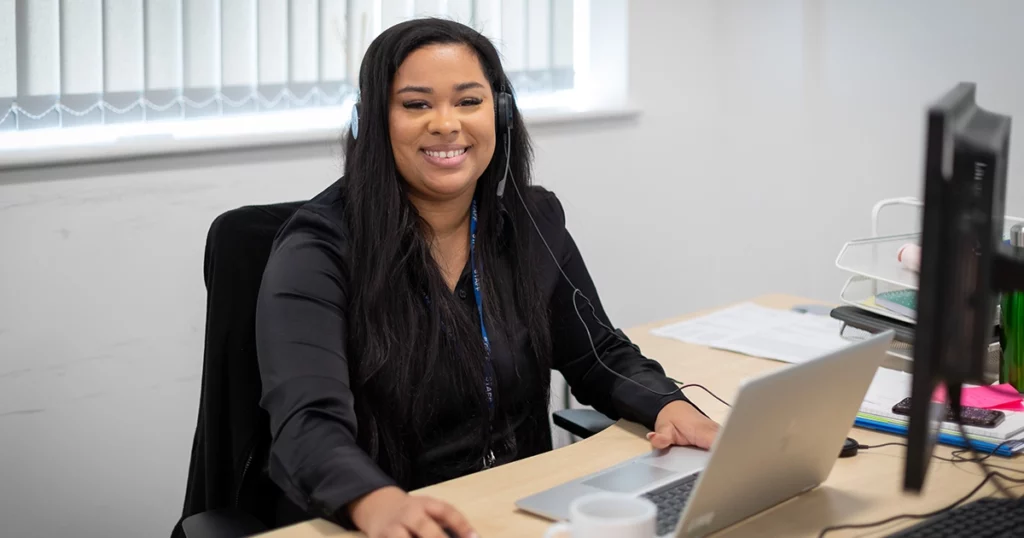 A happy woman working on a laptop